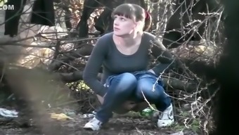 Two college girls squat and pee in the woods